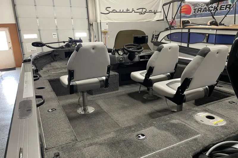 Slide: The Image of 2014 Crestliner 1750 Fish Hawk interior with seating and control console in a showroom. - 8