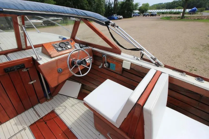 Slide: The Image of 1963 Thompson Skiff Craft 21 boat interior with wooden dashboard and white seating. - 11