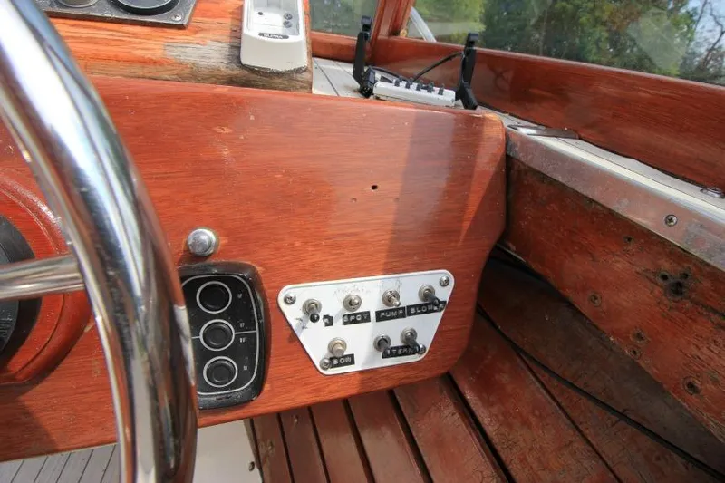 Slide: The Image of 1963 Thompson Skiff Craft 21 dashboard with wooden panel and control switches. - 14