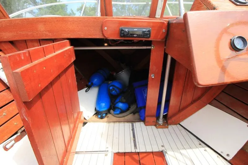 Slide: The Image of 1963 Thompson Skiff Craft 21 interior with wooden storage and blue fenders. - 17