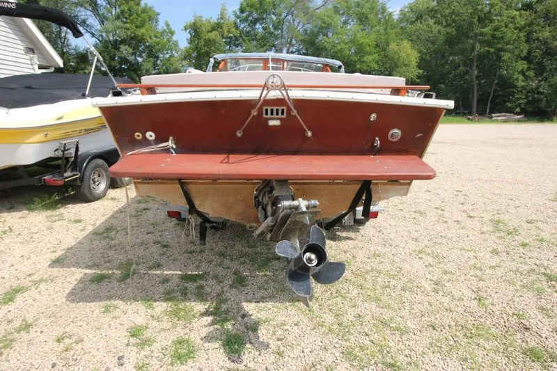 Slide: The Image of 1963 Thompson Skiff Craft 21 boat, rear view, on gravel, with visible propeller and trees in background. - 4