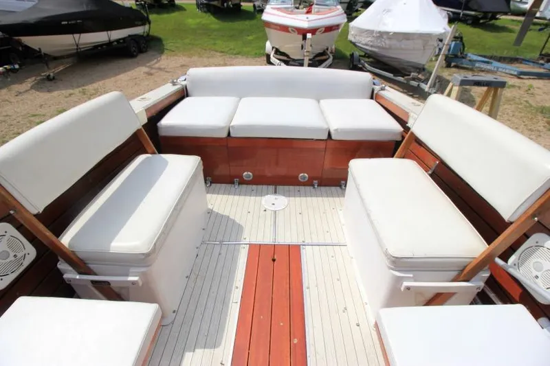 Slide: The Image of 1963 Thompson Skiff Craft 21 boat interior with white cushioned seating and wooden accents. - 6