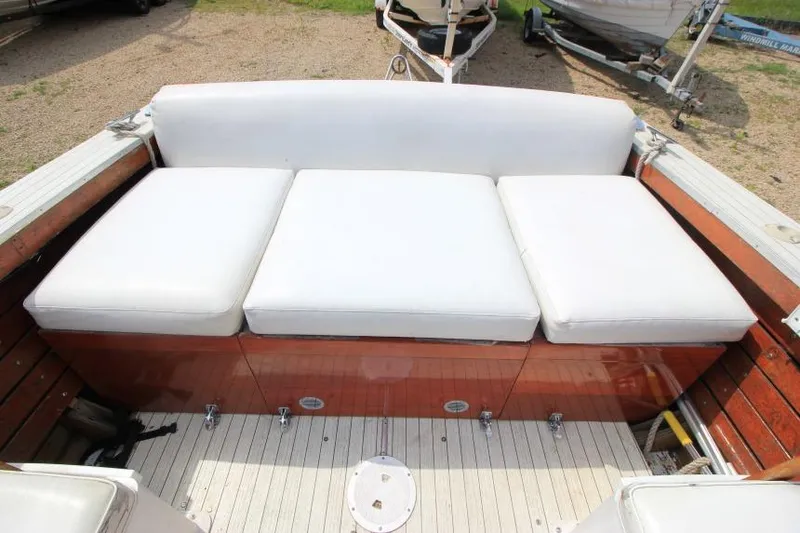 Slide: The Image of 1963 Thompson Skiff Craft 21 boat with white cushioned seating and wooden deck. - 7