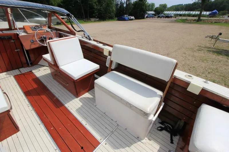 Slide: The Image of 1963 Thompson Skiff Craft 21 boat interior with wooden deck and white cushioned seats. - 8