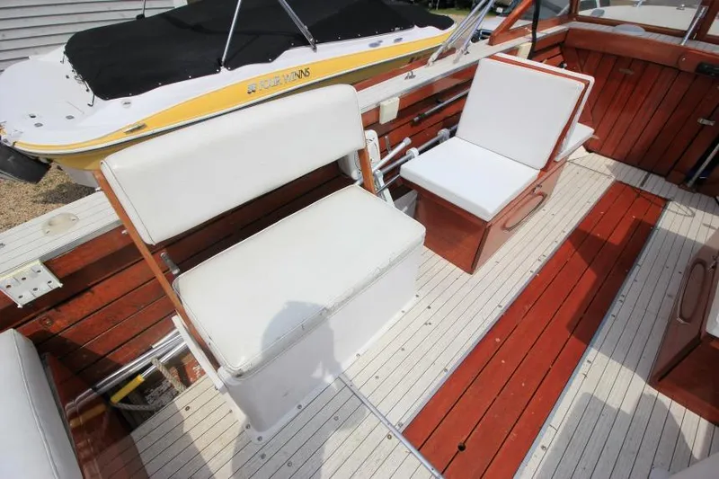 Slide: The Image of 1963 Thompson Skiff Craft 21 interior with white seating and wooden flooring. - 9