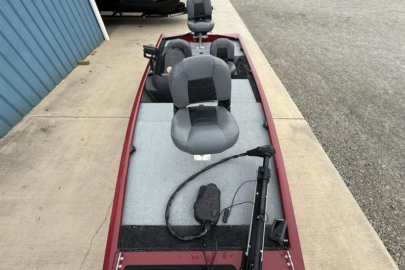 Slide: The Image of 2019 Tracker Pro 170 boat with gray seats and trolling motor, parked on concrete. - 24