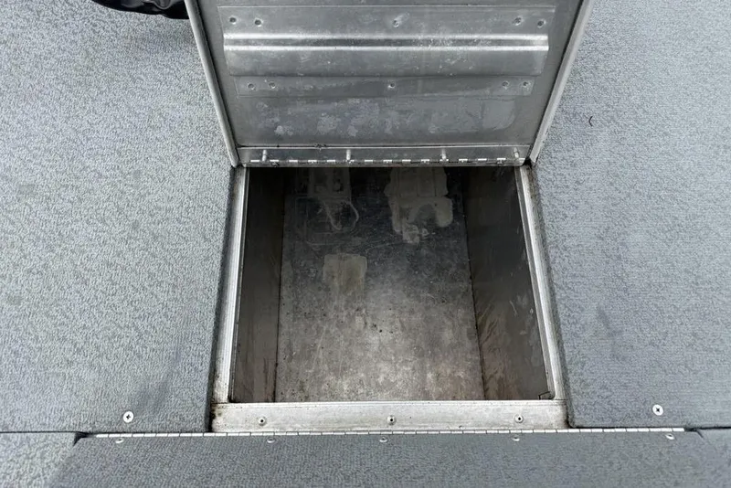 Slide: The Image of Open storage compartment on 2019 Tracker Pro 170 boat, featuring metal interior and carpeted exterior. - 5