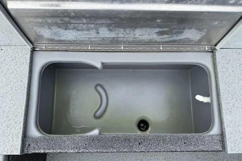 Slide: The Image of 2019 Tracker Pro 170 livewell interior with open lid, showing plumbing and textured surface. - 6
