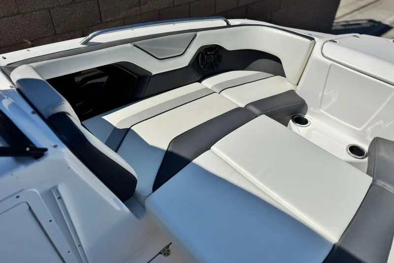 Slide: The Image of 2022 Yamaha Boats 212 interior seating with sleek, modern design and cup holders. - 10