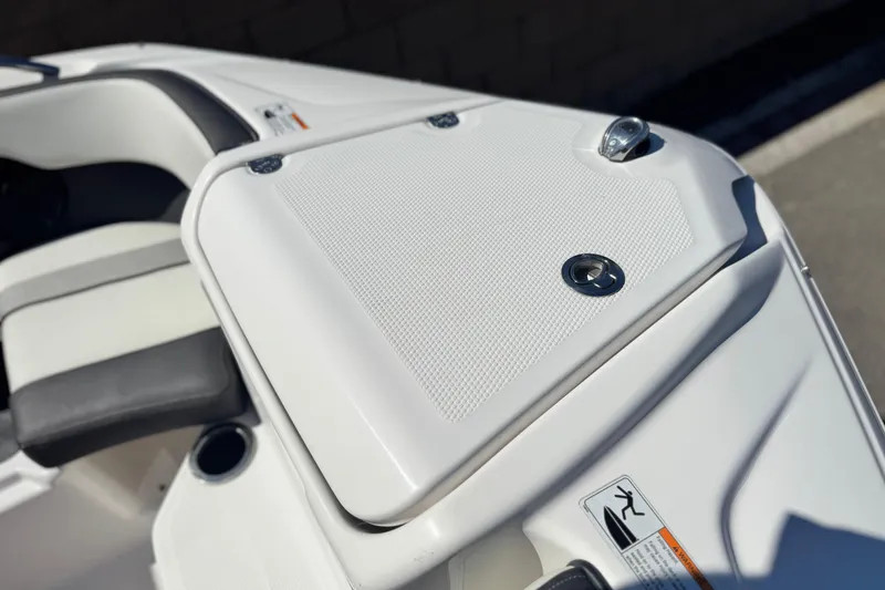 Slide: The Image of 2022 Yamaha Boats 212, white deck detail with seating and storage compartment. - 13
