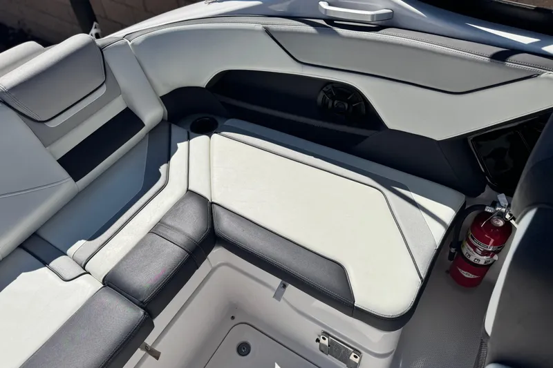 Slide: The Image of Interior seating of a 2022 Yamaha Boats 212, featuring sleek design and a fire extinguisher. - 18