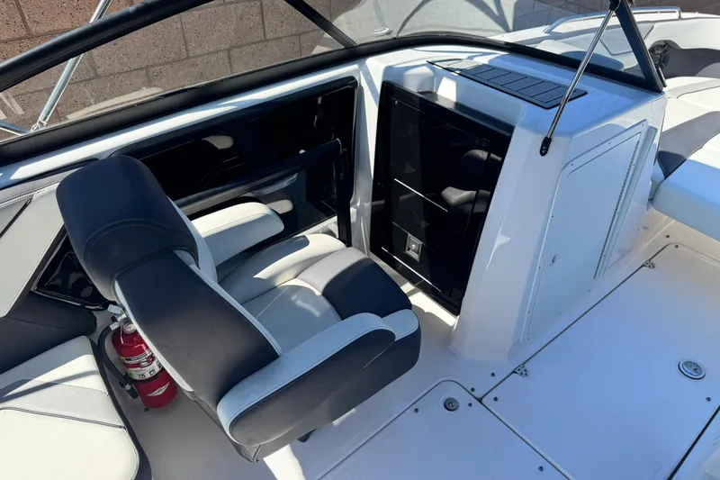 Slide: The Image of 2022 Yamaha Boats 212 interior with seating and storage, featuring a fire extinguisher. - 22