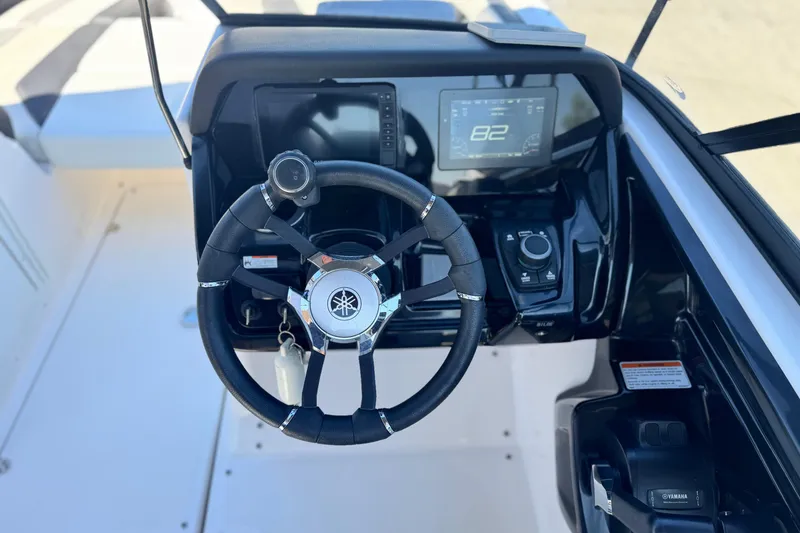 Slide: The Image of 2022 Yamaha Boats 212 dashboard with steering wheel and digital display. - 25