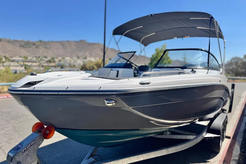 Slide: The Image of 2022 Yamaha Boats 212 on trailer, sleek design, parked outdoors under clear blue sky. - 3