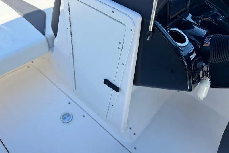 Slide: The Image of 2022 Yamaha Boats 212 interior, featuring helm controls and storage compartment. - 31