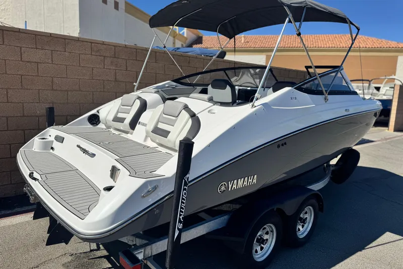 Slide: The Image of 2022 Yamaha Boats 212 on trailer, featuring sleek design and comfortable seating. - 5
