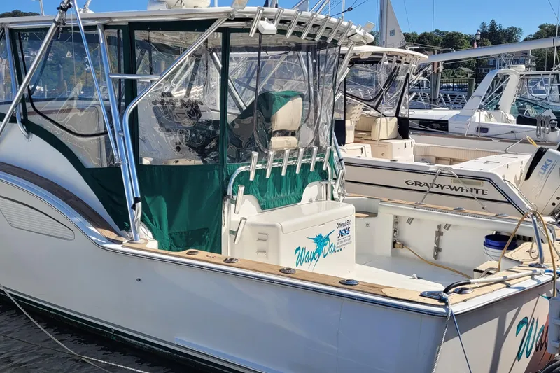 Slide: The Image of 2002 SeaTek 36 Express boat docked, featuring green canopy and sleek design. - 30