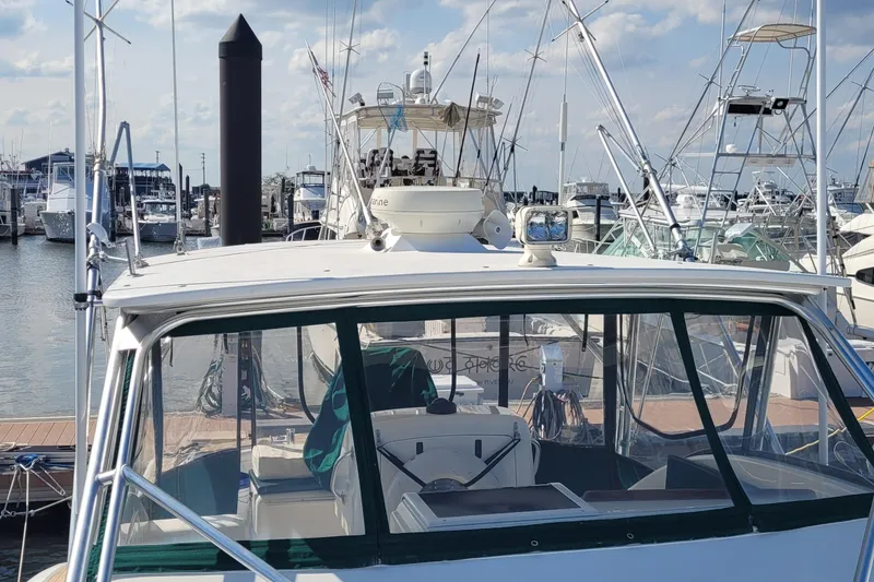Slide: The Image of 2002 SeaTek 36 Express boat docked at a marina, surrounded by other vessels. - 35