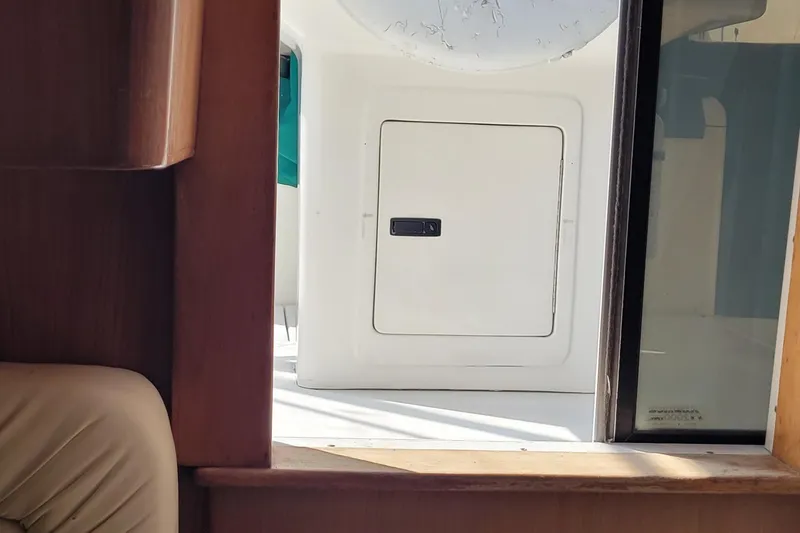 Slide: The Image of Interior view of a 2002 SeaTek 36 Express boat, featuring a cabin window and door. - 42