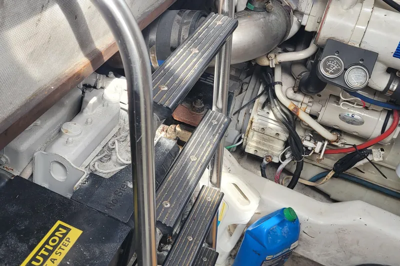 Slide: The Image of Engine compartment of a 2002 SeaTek 36 Express boat with visible machinery and ladder. - 67