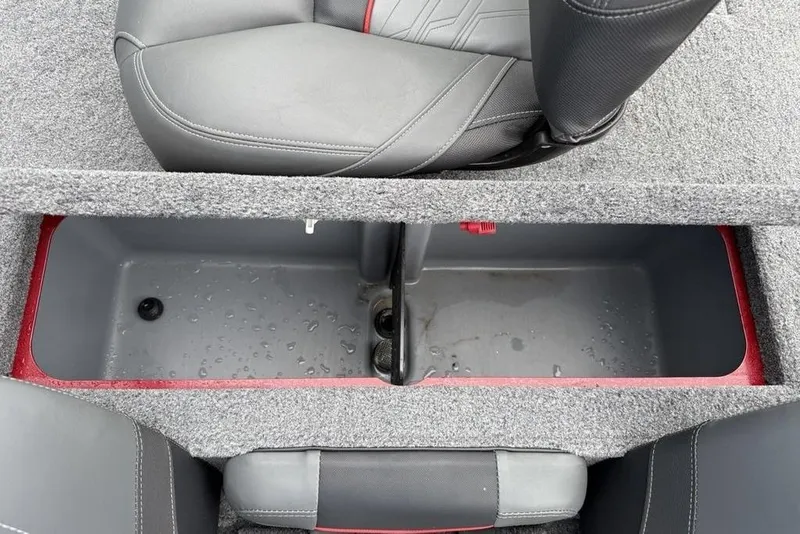 Slide: The Image of 2024 Tracker Pro Team 175 TXW® boat storage compartment with gray seating and red accents. - 14