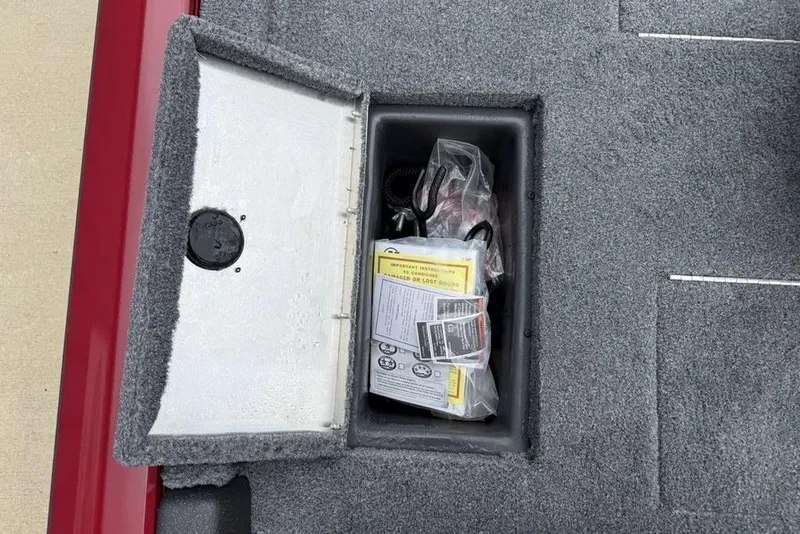 Slide: The Image of Storage compartment of 2024 Tracker Pro Team 175 TXW® boat with manuals and accessories. - 15