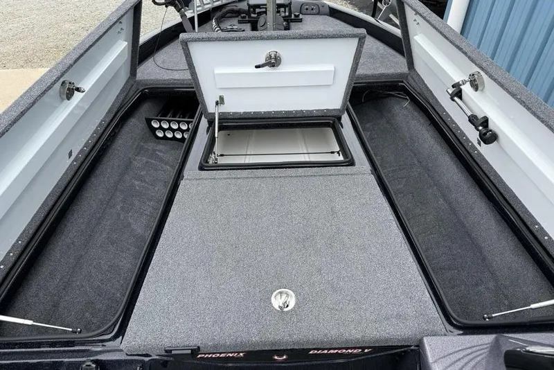 Slide: The Image of 2019 Phoenix 921 PRO XP boat interior with open storage compartments and rod holders. - 6
