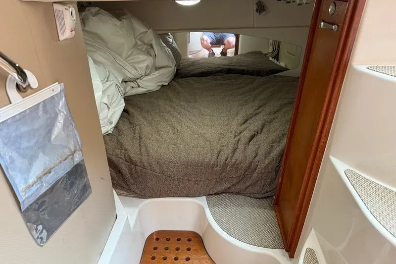 Slide: The Image of 2008 Grady-White Express 360 cabin interior with bed and wooden accents. - 13