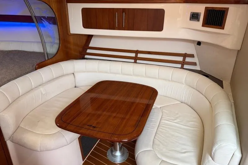 Slide: The Image of 2008 Grady-White Express 360 interior with white leather seating and wooden table. - 15
