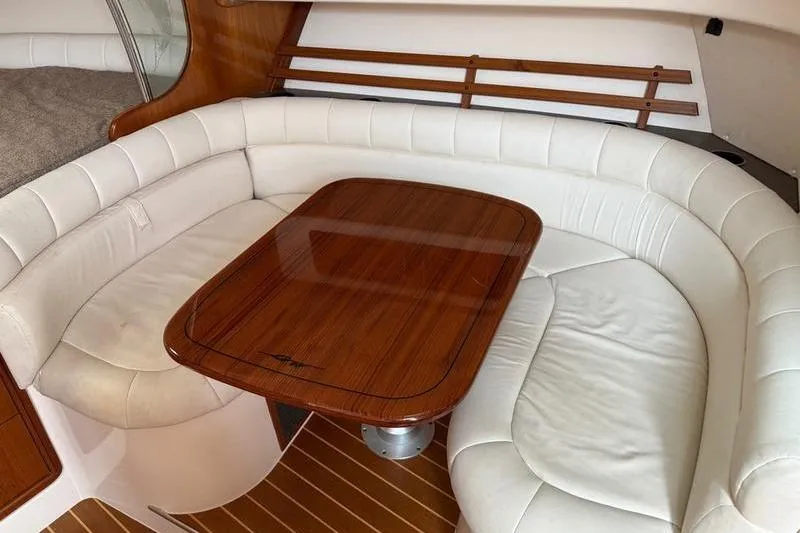 Slide: The Image of 2008 Grady-White Express 360 interior with white leather seating and wooden table. - 18