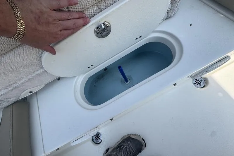 Slide: The Image of 2019 Key West 219fs boat livewell with open lid and hand resting on it. - 9