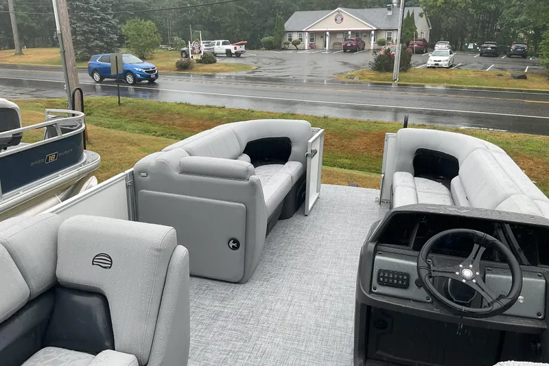 Slide: The Image of 2026 Sun Tracker PB 20 DLX pontoon boat interior with gray seating and steering console. - 10