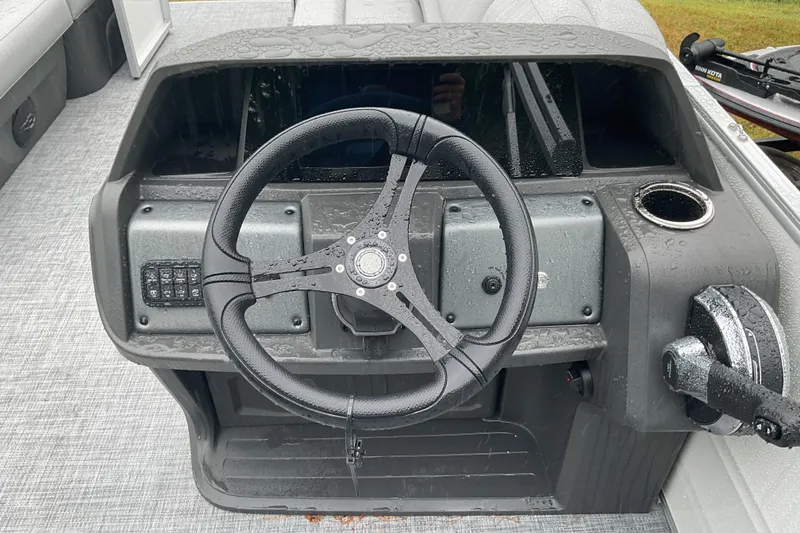 Slide: The Image of 2026 Sun Tracker PB 20 DLX boat dashboard with steering wheel and controls. - 11