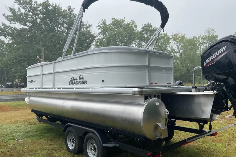 Slide: The Image of 2026 Sun Tracker PB 20 DLX pontoon boat on trailer, featuring Mercury outboard motor. - 5