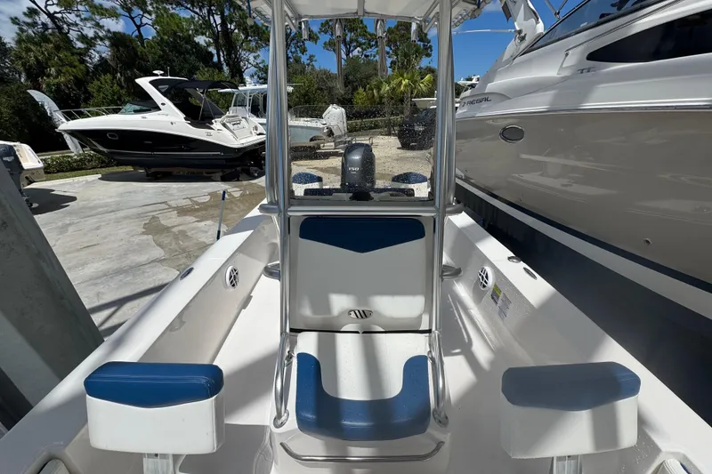 Slide: The Image of 2022 Robalo 206 Cayman boat interior with blue and white seating, docked near other boats. - 10