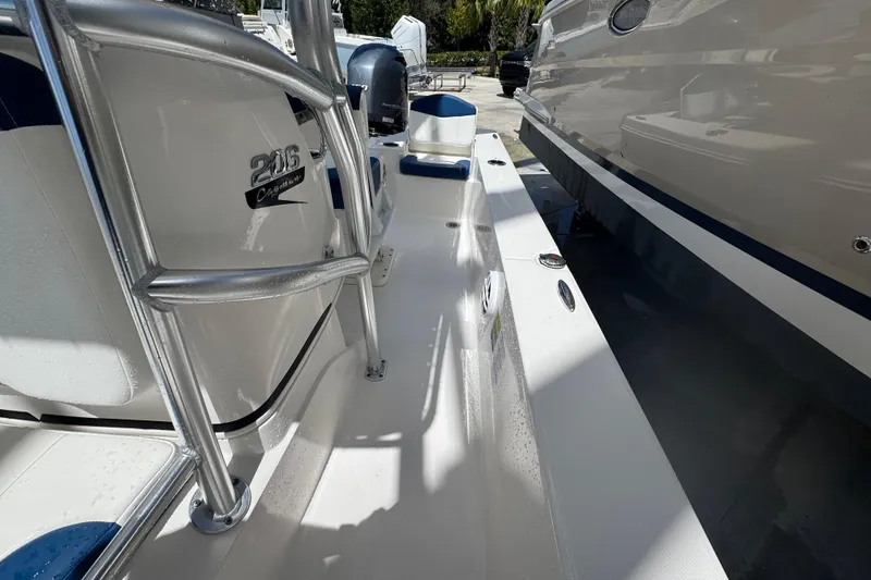 Slide: The Image of 2022 Robalo 206 Cayman boat deck with seating and railing, parked outdoors. - 11