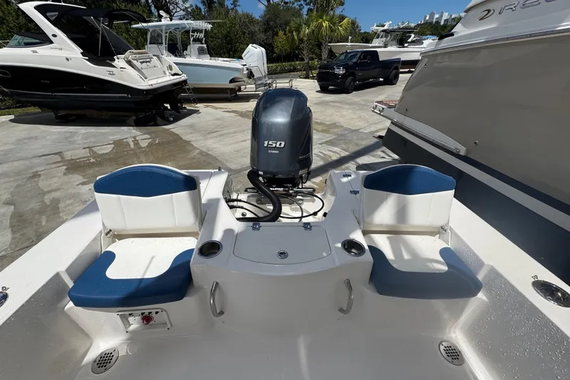 Slide: The Image of 2022 Robalo 206 Cayman boat with Yamaha 150 engine, docked alongside other boats. - 13