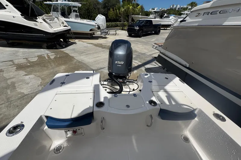 Slide: The Image of 2022 Robalo 206 Cayman boat with 150 horsepower engine, docked among other boats. - 14