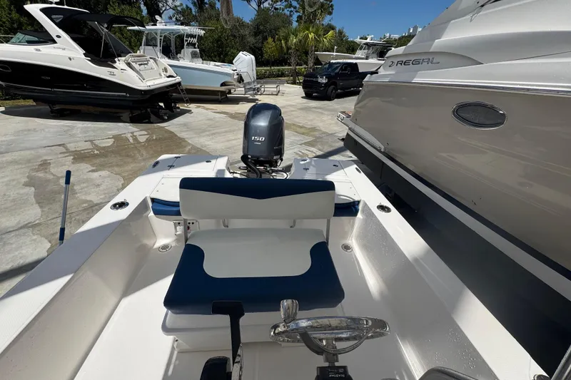 Slide: The Image of 2022 Robalo 206 Cayman boat with 150 HP engine, docked alongside other boats. - 15