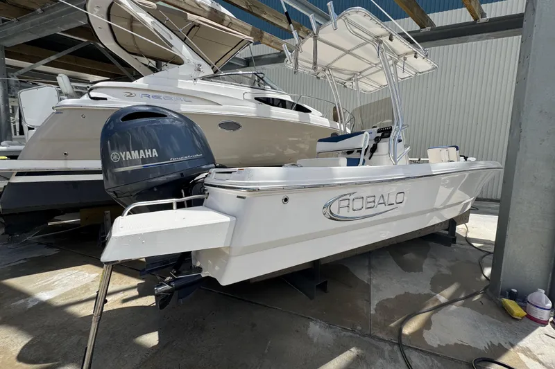Slide: The Image of 2022 Robalo 206 Cayman boat with Yamaha engine, parked in a marina. - 17