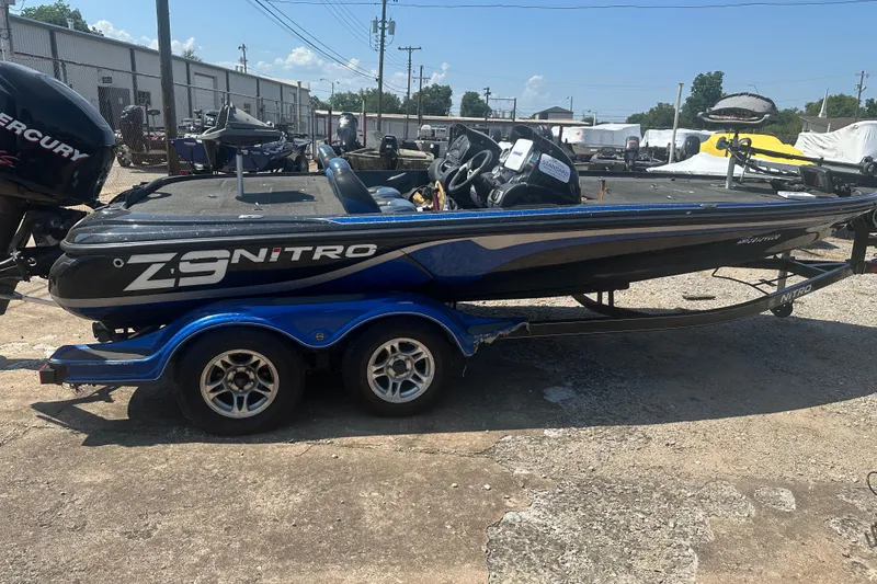 Slide: The Image of 2012 Nitro Z-9 boat on trailer, parked outdoors, featuring sleek design and dual axles. - 1