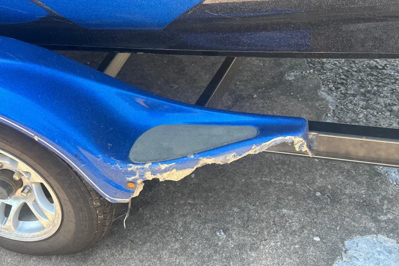 Slide: The Image of Damaged blue fender on 2012 Nitro Z-9 boat trailer, showing wear and tear. - 16