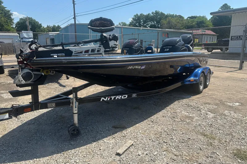Slide: The Image of 2012 Nitro Z-9 boat on trailer, parked outdoors, featuring Minn Kota motor. - 3