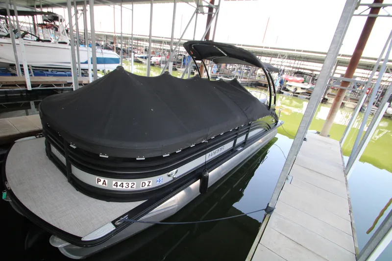 Slide: The Image of 2020 Harris FloteBote Solstice 250 SL pontoon boat docked with cover in marina. - 45