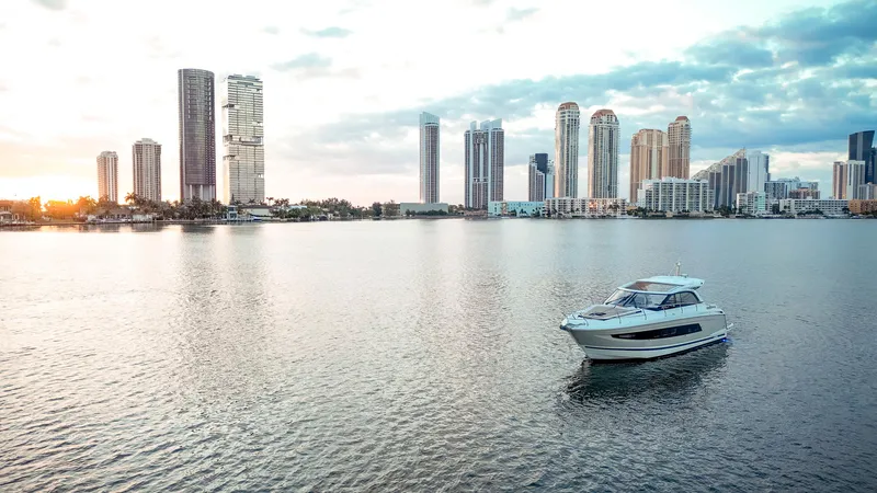 Slide: The Image of 2017 Jeanneau Leader 40 yacht cruising near city skyline at sunset. - 43