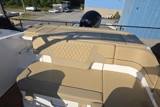 Slide: The Image of 2025 Bayliner VR5 OB boat with tan cushioned seating and outboard motor. - 17