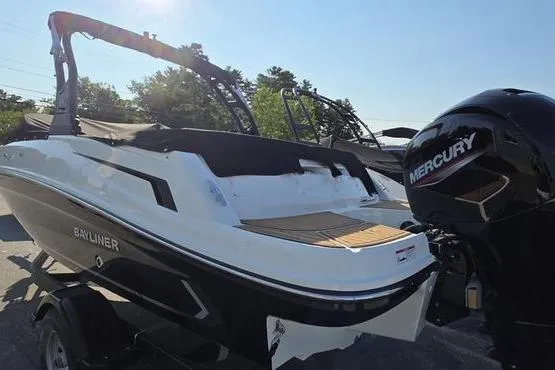 Slide: The Image of 2025 Bayliner VR5 OB boat with Mercury outboard engine, parked on a trailer. - 2