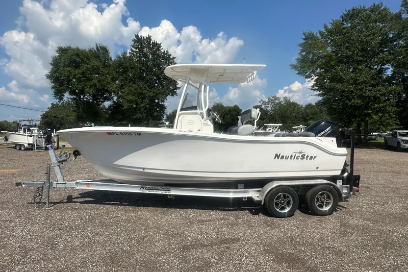 Slide: The Image of 2023 NauticStar 2102 Legacy boat on trailer, parked outdoors under a clear sky. - 1
