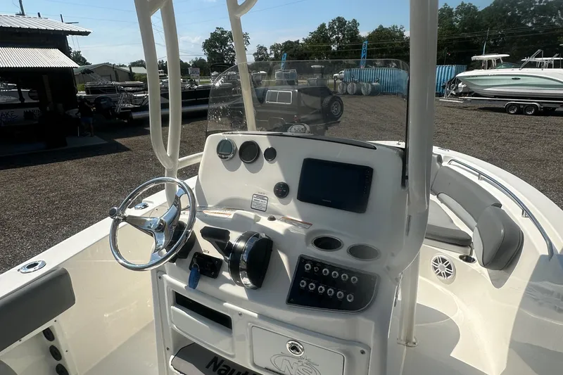 Slide: The Image of 2023 NauticStar 2102 Legacy boat dashboard with steering wheel and controls. - 11