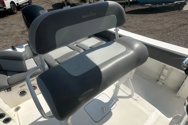 Slide: The Image of 2023 NauticStar 2102 Legacy boat interior with gray seating and helm station. - 18
